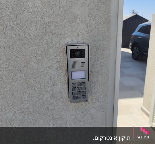 אינטרקום מותקן על קיר חיצוני ליד חניה